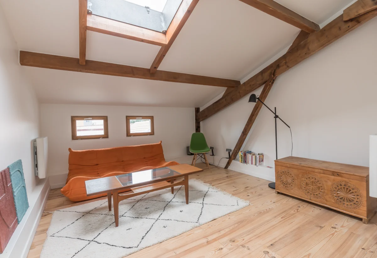 Attic studio with timber beams and mezzanine