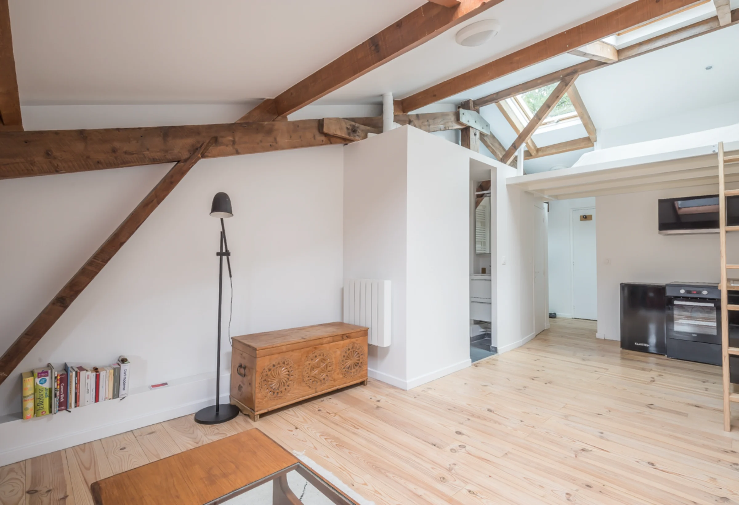 Studio sous combles avec poutres en bois et mezzanine · 03