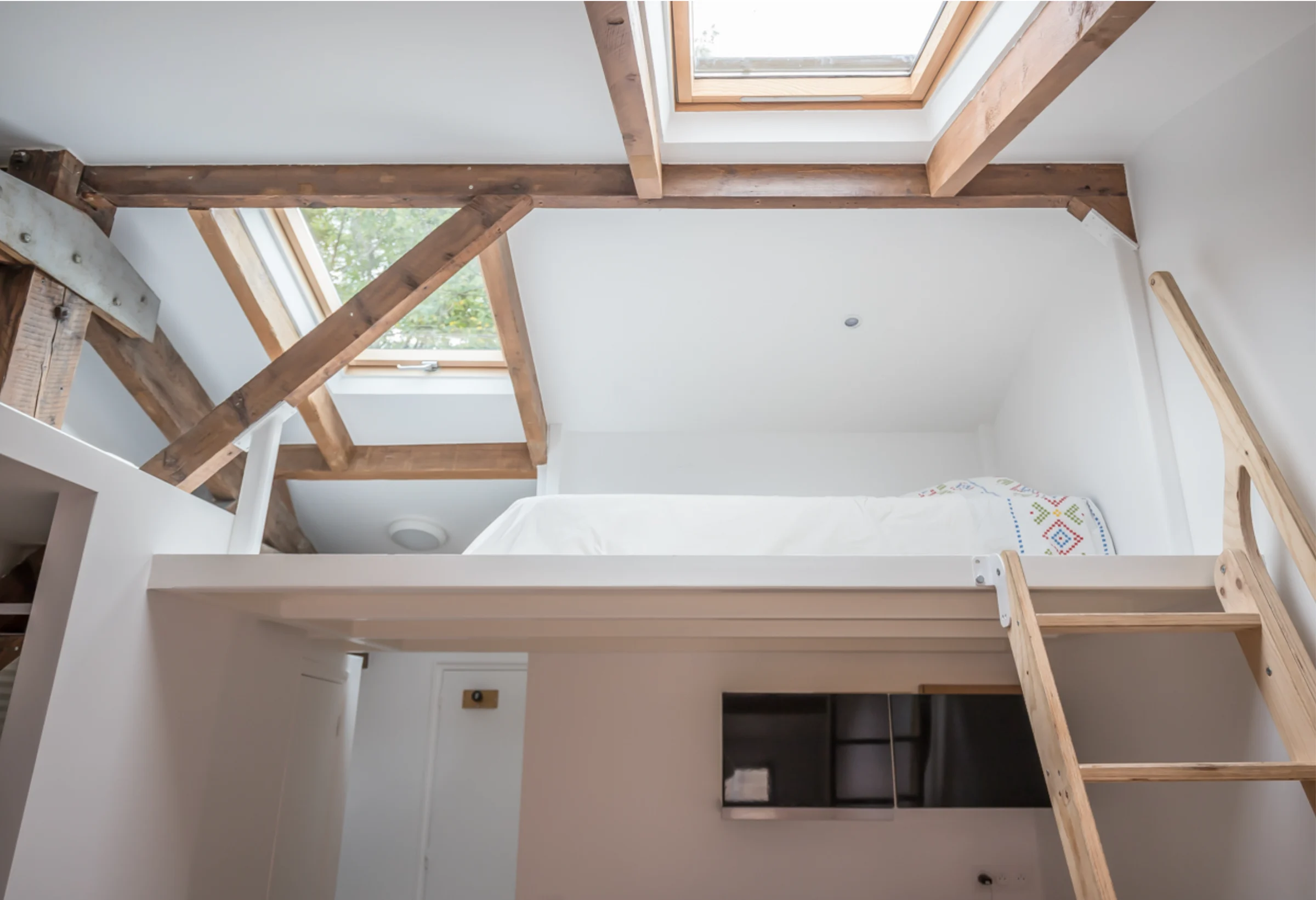 Studio sous combles avec poutres en bois et mezzanine · 05